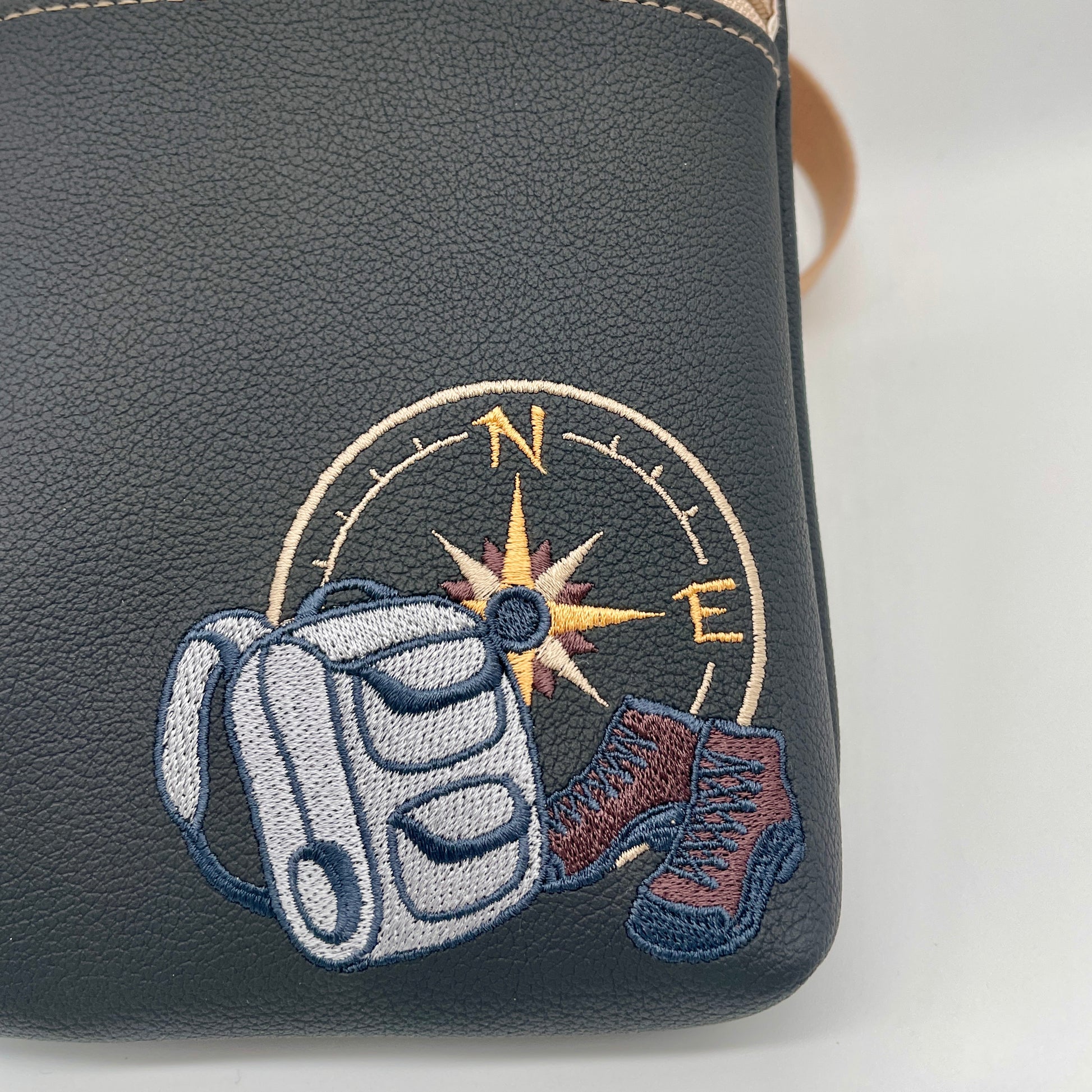 gros plan broderie sac à dos et rose des vents de la sacoche Bop homme